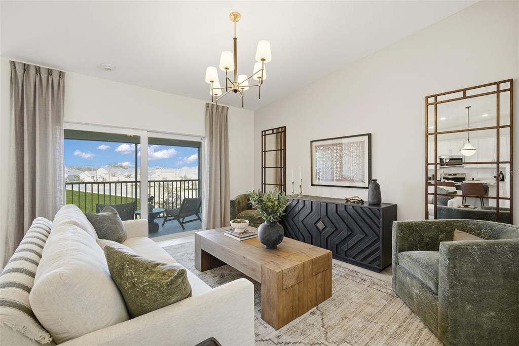 A living room features a white sofa, green armchairs, a wooden coffee table, and a mirror — 18911 SCALLOP LOOP UNIT 205, LAKEWOOD RANCH, FL