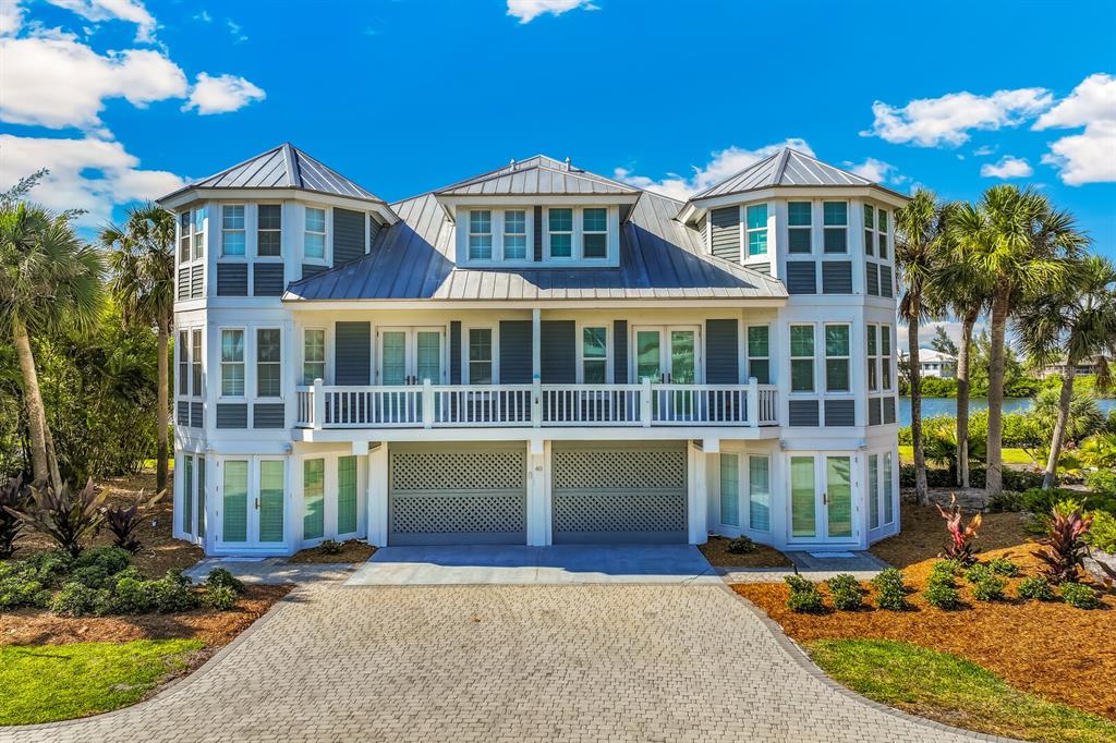 A three-story house with a metal roof, white trim, and a paved driveway — 40 SEAWATCH LAKE DRIVE, BOCA GRANDE, FL
