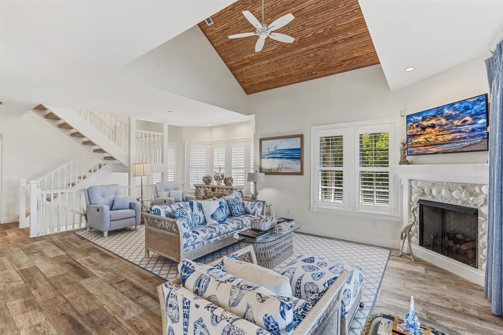 A living room features a vaulted wood-paneled ceiling, a shell-covered fireplace, and coastal-themed furniture — 40 SEAWATCH LAKE DRIVE, BOCA GRANDE, FL