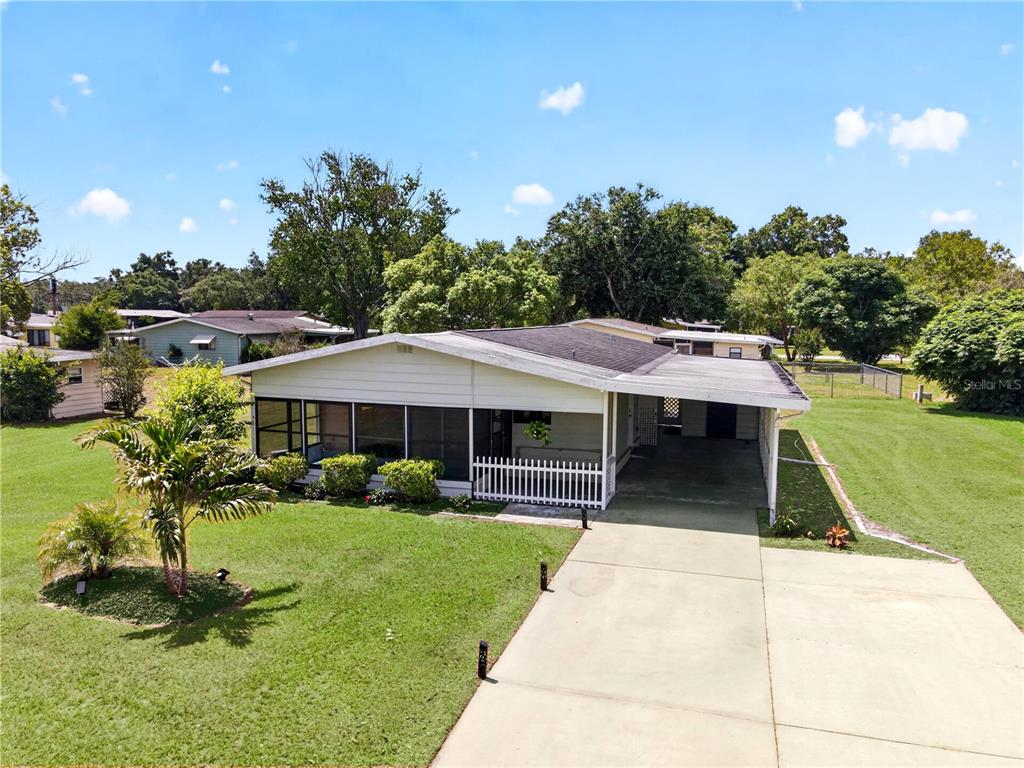 A single-story house exterior features a screened-in porch, white siding, and a white picket fence — 8972 SW 103RD LANE, OCALA, FL