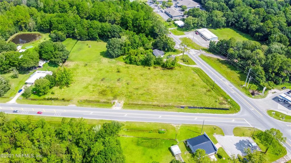 An aerial view shows a large, grassy vacant lot bordered by roads and trees — 10422 SE SR 100, STARKE, FL