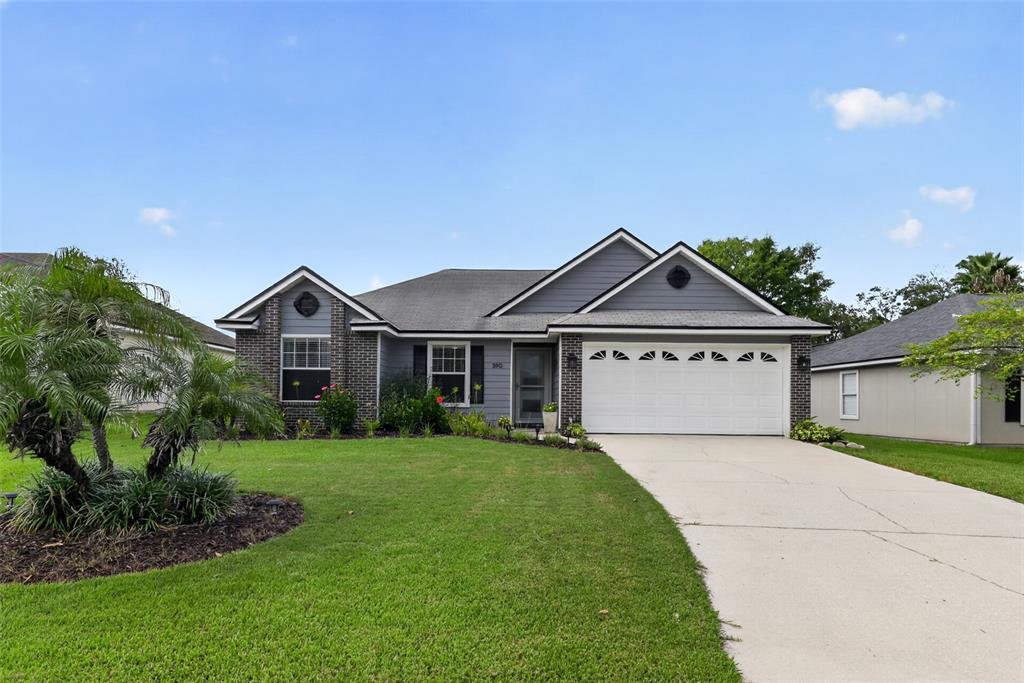 A single-story house with a gray brick and siding exterior, a two-car garage, and lawn — 590 ASHCROFT LANDING DRIVE, JACKSONVILLE, FL