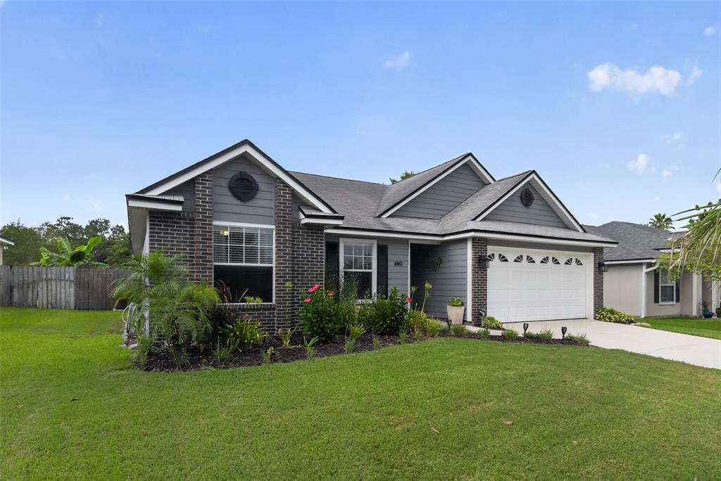 A single-story house with a gray brick and siding exterior, a garage, and a lawn — 590 ASHCROFT LANDING DRIVE, JACKSONVILLE, FL