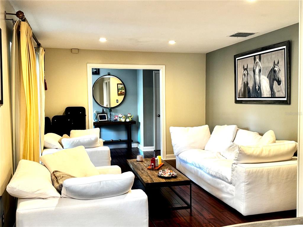 A living room features white sofas, a wooden coffee table, and a horse-themed wall print — 414 TIMBERCOVE CIRCLE, LONGWOOD, FL