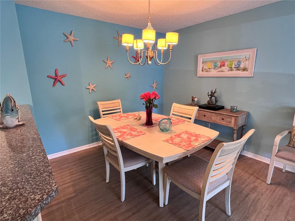 A kitchen with white cabinets, blue walls, a speckled countertop, and a tile floor — 4040 CROCKERS LAKE BOULEVARD UNIT 1717, SARASOTA, FL