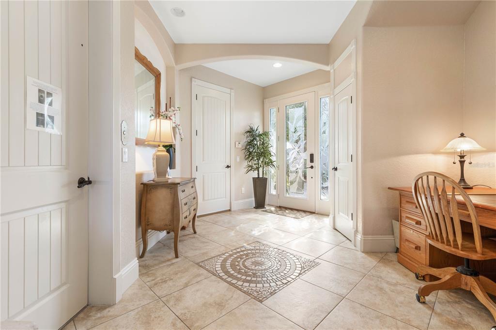 A tiled entryway features an arched ceiling, a decorative floor inlay, and a wooden desk — 12 CINNAMON BEACH WAY, PALM COAST, FL