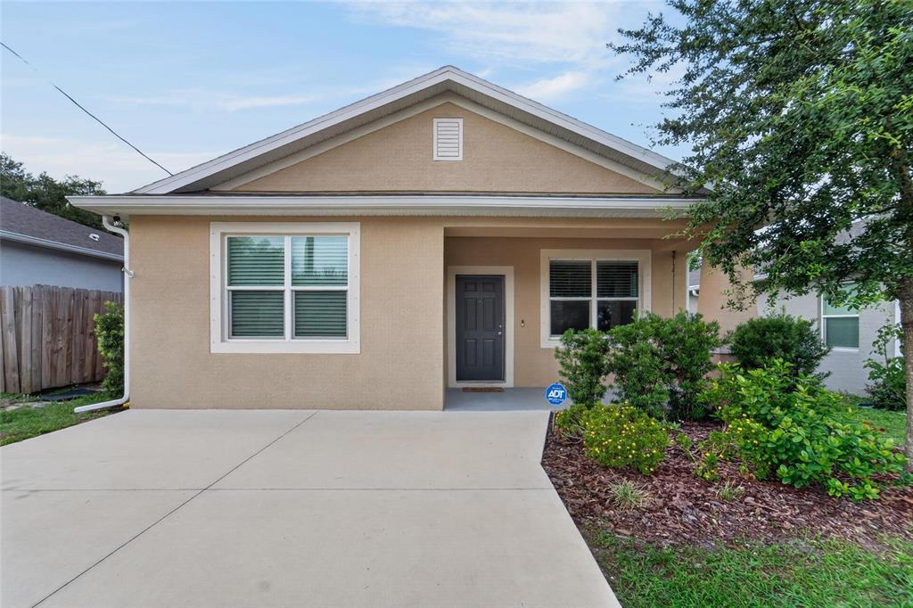 A single-story house with a beige stucco exterior, a concrete driveway, and a front porch — 3507 E 10TH AVENUE, TAMPA, FL