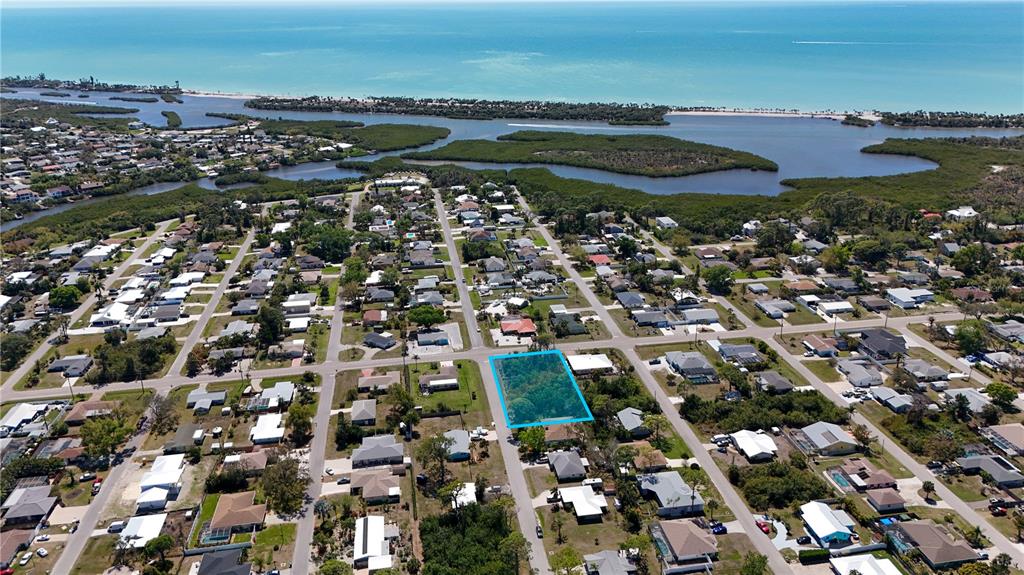 An aerial view shows a vacant, tree-covered lot highlighted in blue within a residential neighborhood — FUNDY ROAD, VENICE, FL