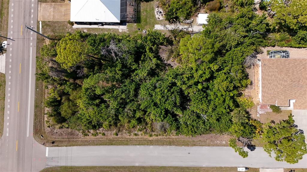 An aerial view shows a vacant, tree-covered lot situated between two residential properties — FUNDY ROAD, VENICE, FL