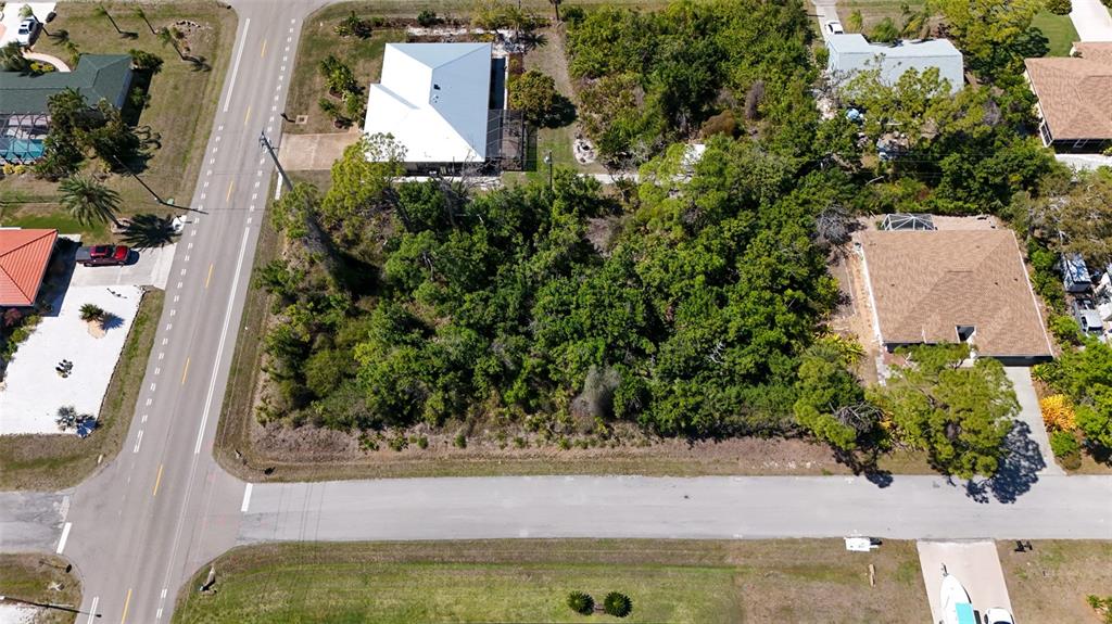 An aerial view shows a vacant, wooded lot situated between two residential houses and two roads — FUNDY ROAD, VENICE, FL