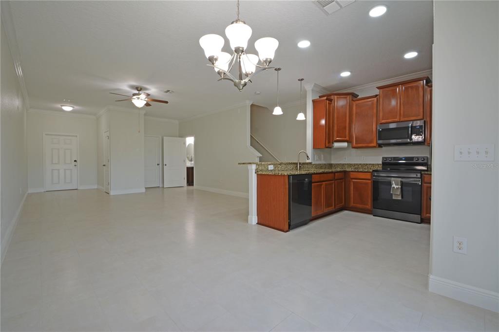A covered entryway features a brown front door, a garage door, and a brick-patterned floor — 11925 GREENGATE DRIVE, HUDSON, FL