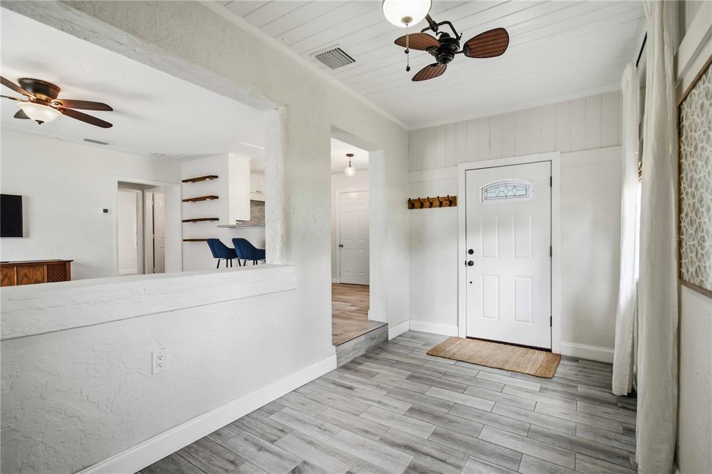 An entryway with gray wood-look tile flooring, a white front door, and a ceiling fan — 2924 HILLVIEW STREET, SARASOTA, FL