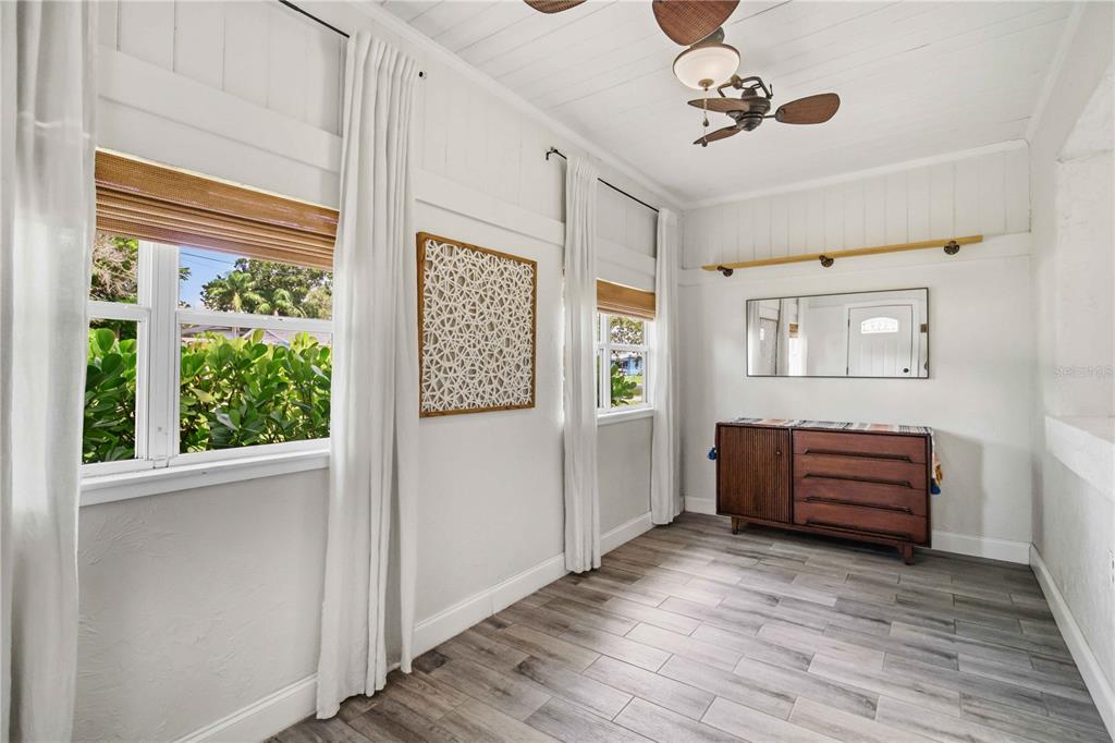 A bright room with white walls, wood-look tile flooring, a ceiling fan, and a wooden dresser — 2924 HILLVIEW STREET, SARASOTA, FL