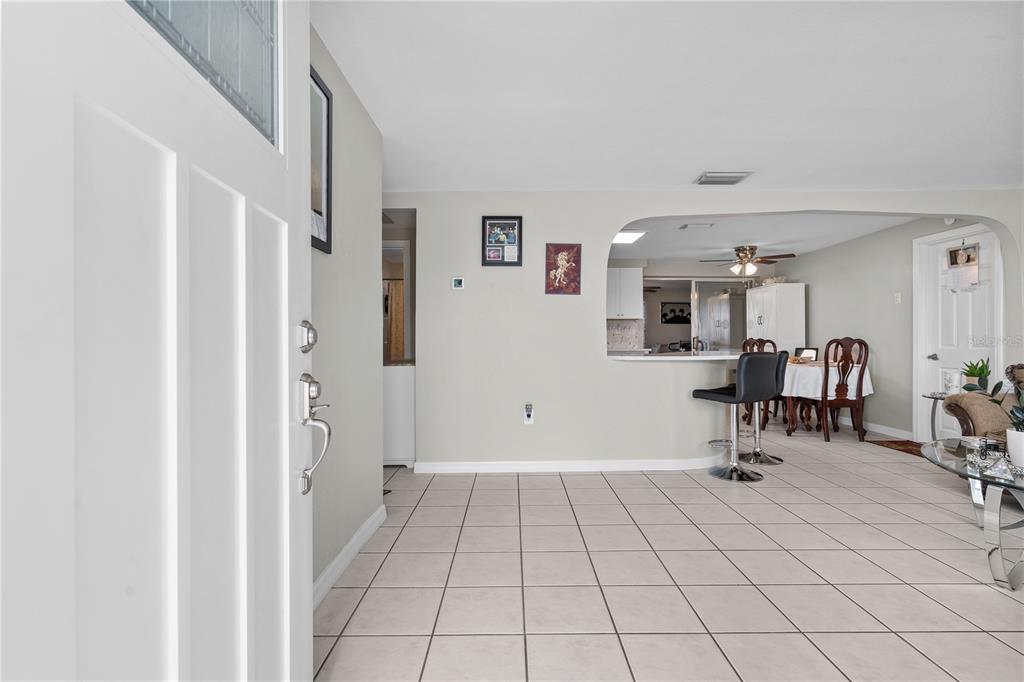 An entryway opens into a tiled living area with a breakfast bar and dining space — 13323 NEPTUNE DRIVE, HUDSON, FL