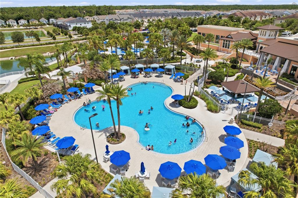An aerial view shows a large, Mickey-shaped swimming pool surrounded by lounge chairs and umbrellas — 1122 SEASIDE MIST TRAIL, KISSIMMEE, FL