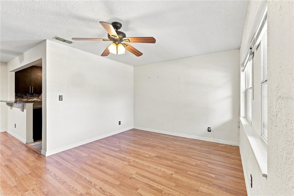 An empty room features wood-look laminate flooring, white walls, and a ceiling fan — 3410 CALUMET DRIVE, ORLANDO, FL