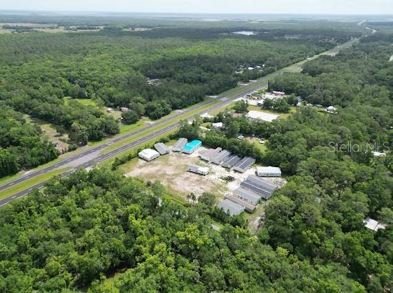 An aerial view shows a cluster of mobile homes on a cleared lot near a highway — 24502 E COLONIAL DRIVE, CHRISTMAS, FL