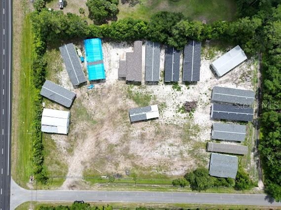 An aerial view shows several mobile homes and structures situated on a large, partially cleared lot — 24502 E COLONIAL DRIVE, CHRISTMAS, FL