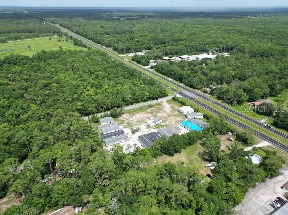 An aerial view shows a cluster of buildings and a pool near a highway — 24502 E COLONIAL DRIVE, CHRISTMAS, FL