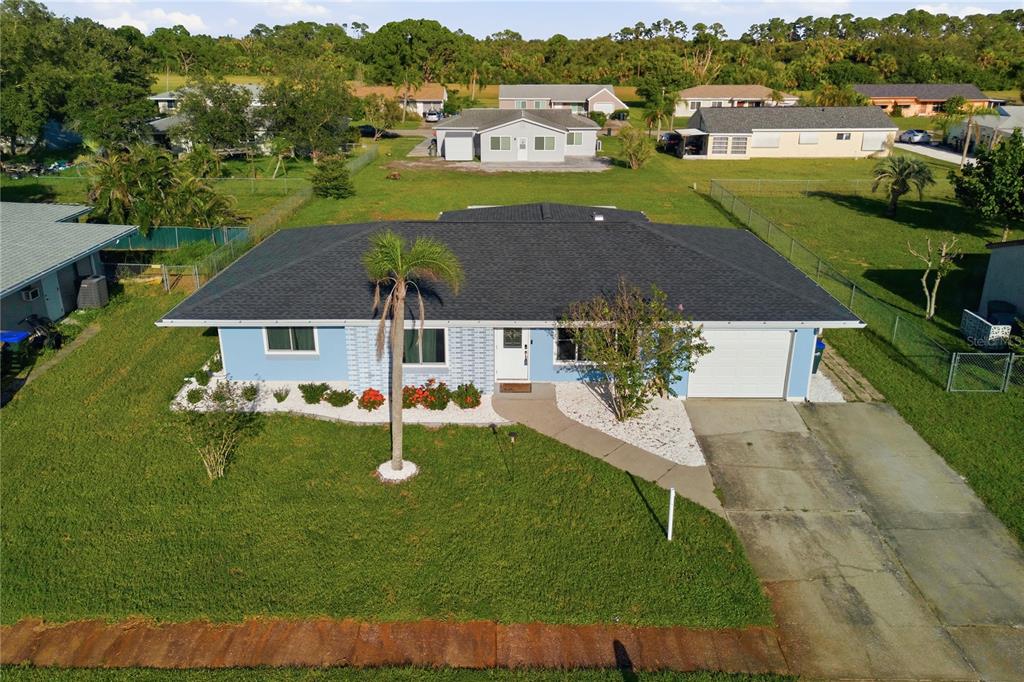 An aerial view of a light blue single-story house with a dark shingled roof — 3634 LULLABY ROAD, NORTH PORT, FL