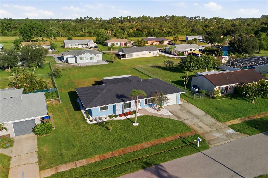 An aerial view of a blue single-story house with a dark roof and driveway — 3634 LULLABY ROAD, NORTH PORT, FL