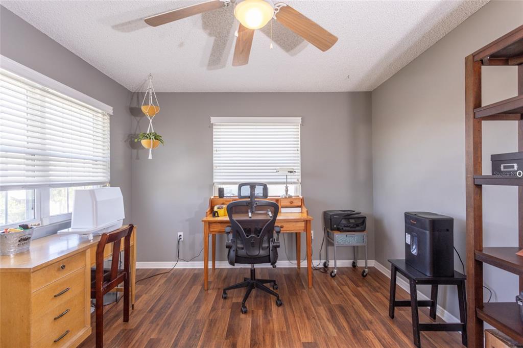 A bedroom with light blue walls, a turtle-patterned quilt, a ceiling fan, and an ensuite bathroom — 44 FLAGLER DRIVE, PALM COAST, FL