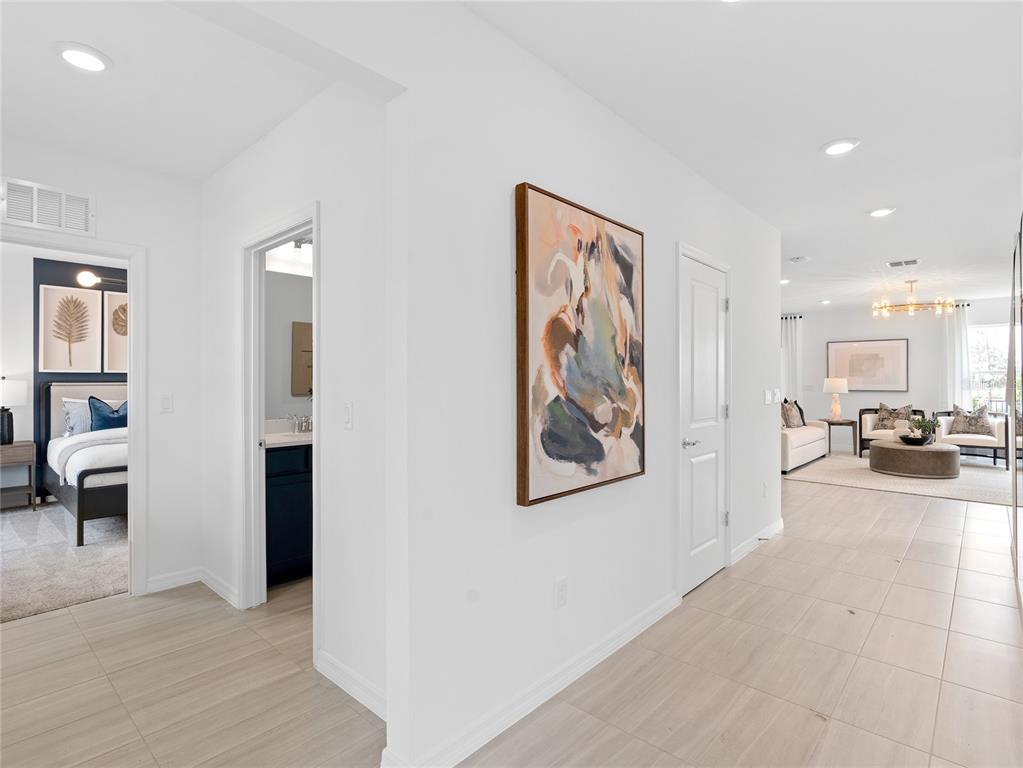 A hallway with light tile flooring leads to a living room and two adjacent rooms — 10764 LEAFY LAUREL STREET, ORLANDO, FL
