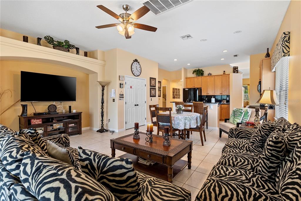 An open-concept living and dining area features zebra-print furniture, tile flooring, and light-colored walls — 358 LAKE DAVENPORT CIRCLE, DAVENPORT, FL
