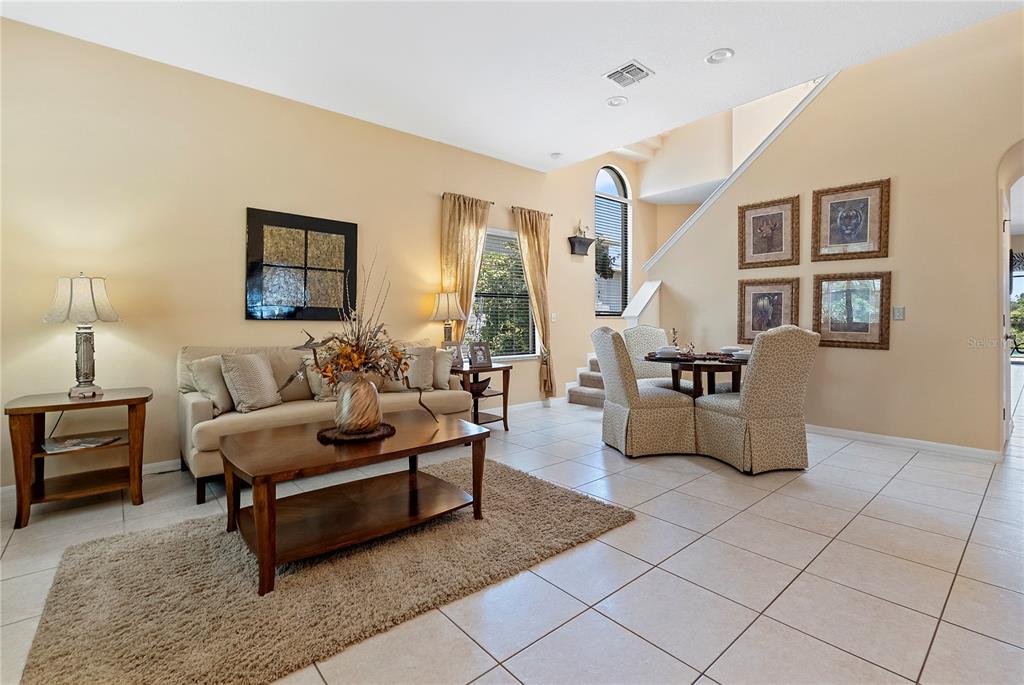 A living and dining area with beige walls, tile floors, and a staircase — 358 LAKE DAVENPORT CIRCLE, DAVENPORT, FL
