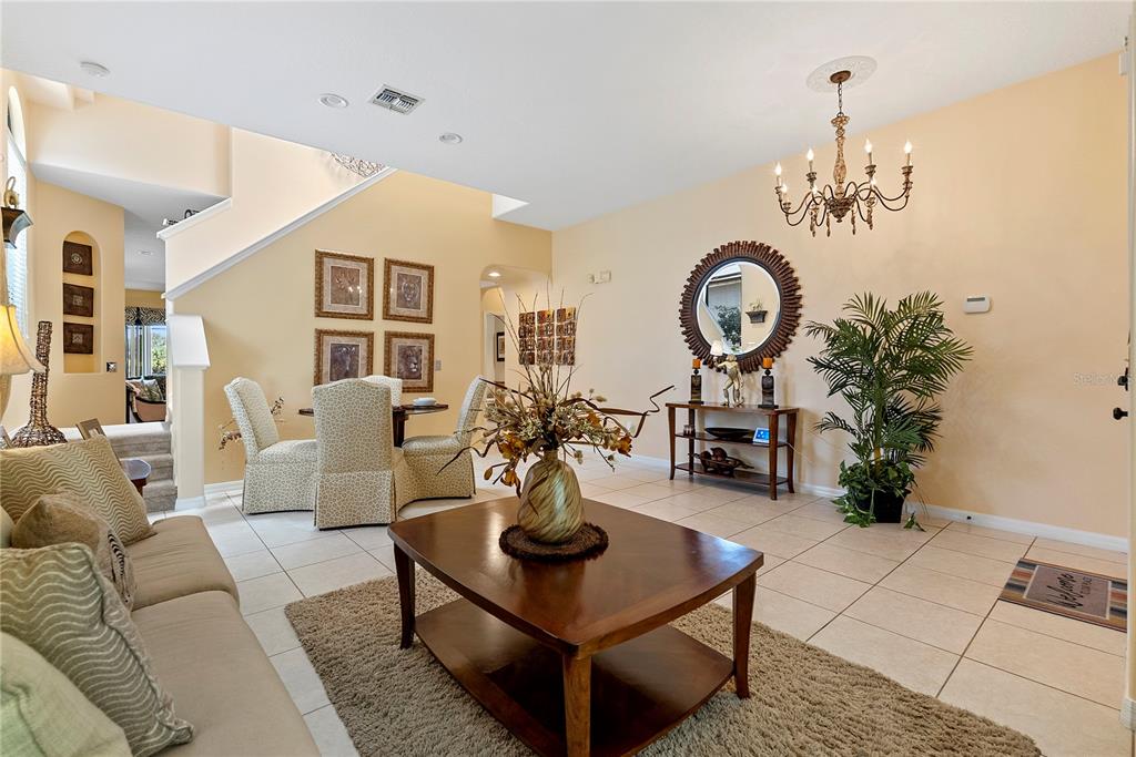 A living room with tile floors, a wooden coffee table, and a dining area nearby — 358 LAKE DAVENPORT CIRCLE, DAVENPORT, FL