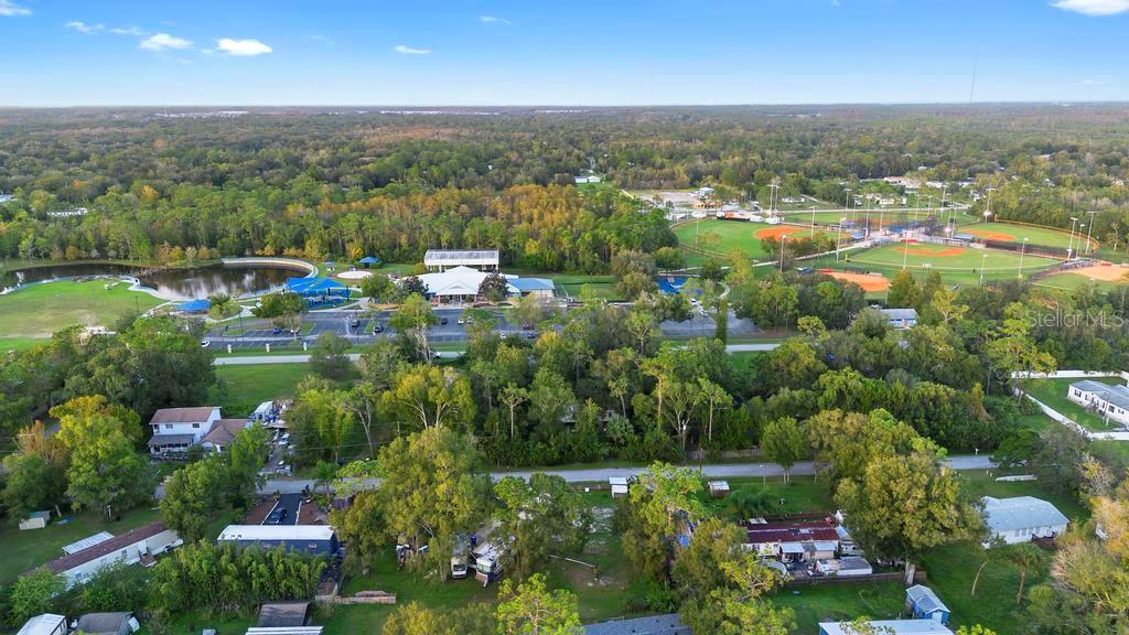 An aerial view shows a residential neighborhood adjacent to a park with baseball fields — 1ST AVENUE, ORLANDO, FL