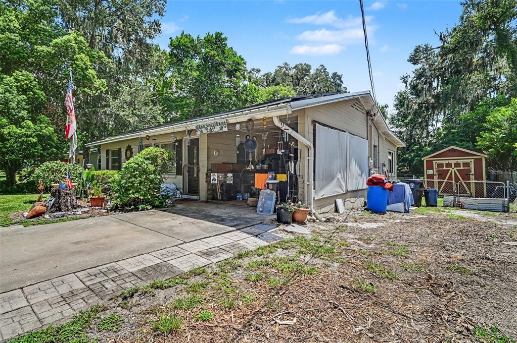 A single-story house with a concrete driveway, a covered porch, and a small storage shed — 624 W FRENCH AVENUE, ORANGE CITY, FL