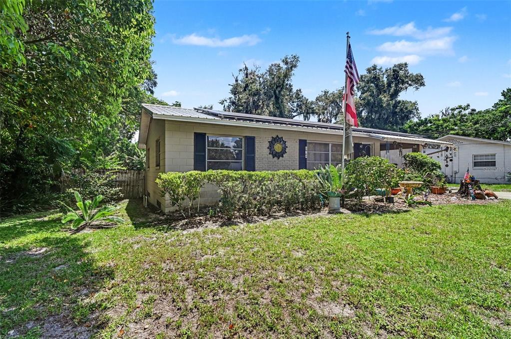 A single-story house with a metal roof, block exterior, and a front yard with landscaping — 624 W FRENCH AVENUE, ORANGE CITY, FL