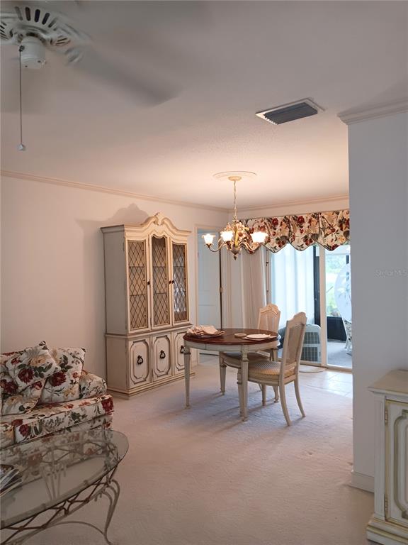 A dining area with a hutch, round table, and chairs sits beside a living room — 980 N GONDOLA DRIVE, VENICE, FL