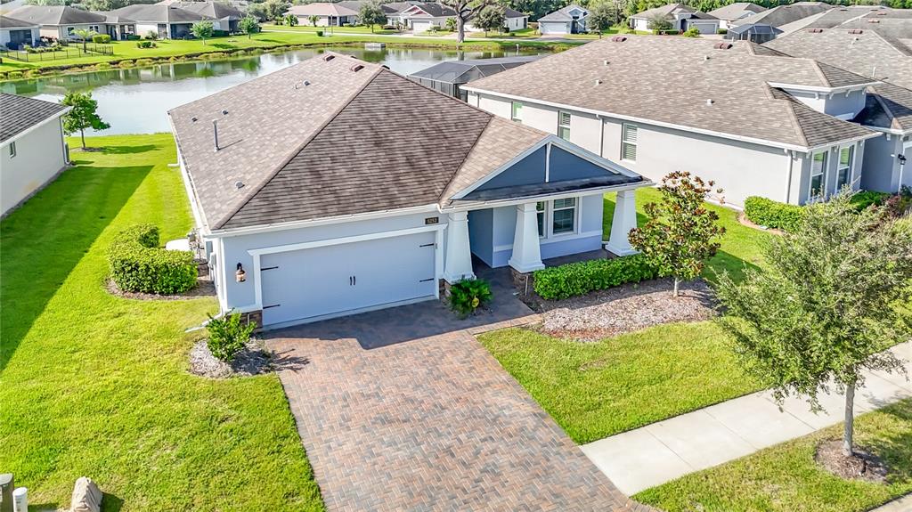 An aerial view shows a single-story house with a paved driveway and a brown roof — 5252 CAPPLEMAN LOOP, BROOKSVILLE, FL