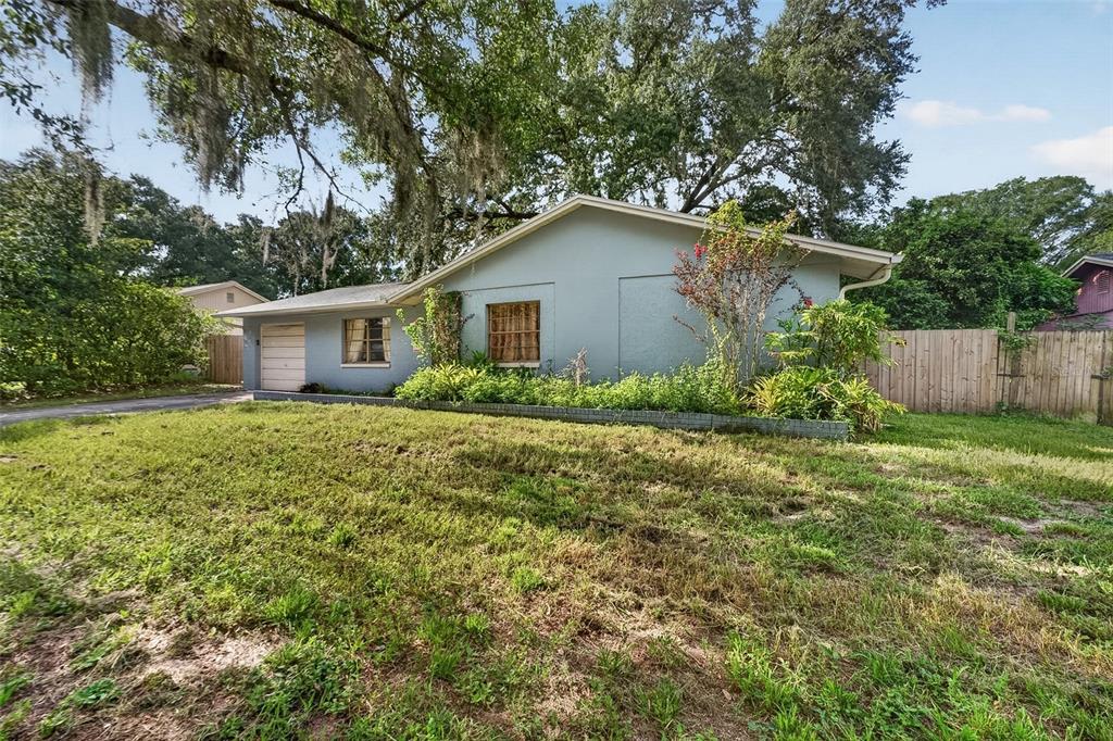 A single-story house with a light blue exterior, a garage, and a large front yard — 1917 CEDARBROOKE DRIVE, LUTZ, FL