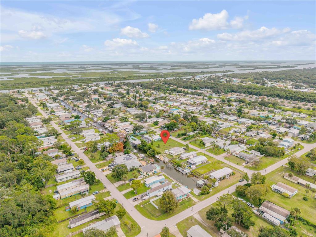 An aerial view shows a residential neighborhood with a canal and a red location pin — 113 CHARLES STREET, EDGEWATER, FL