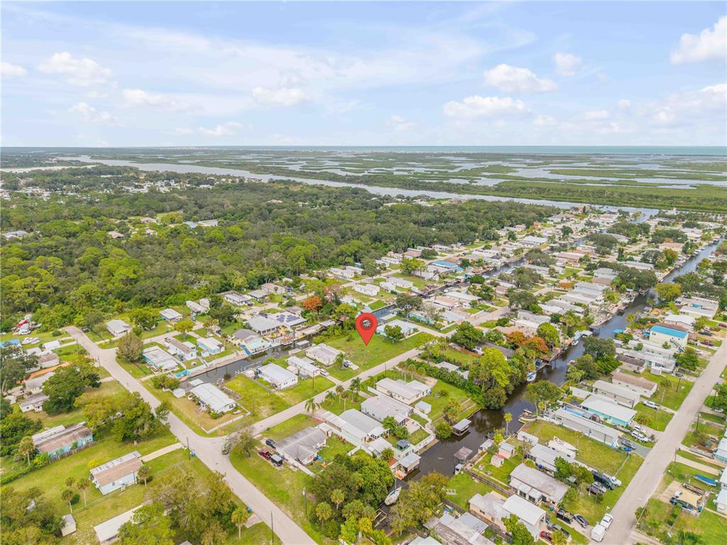 An aerial view shows a vacant lot marked with a red pin in a neighborhood — 113 CHARLES STREET, EDGEWATER, FL