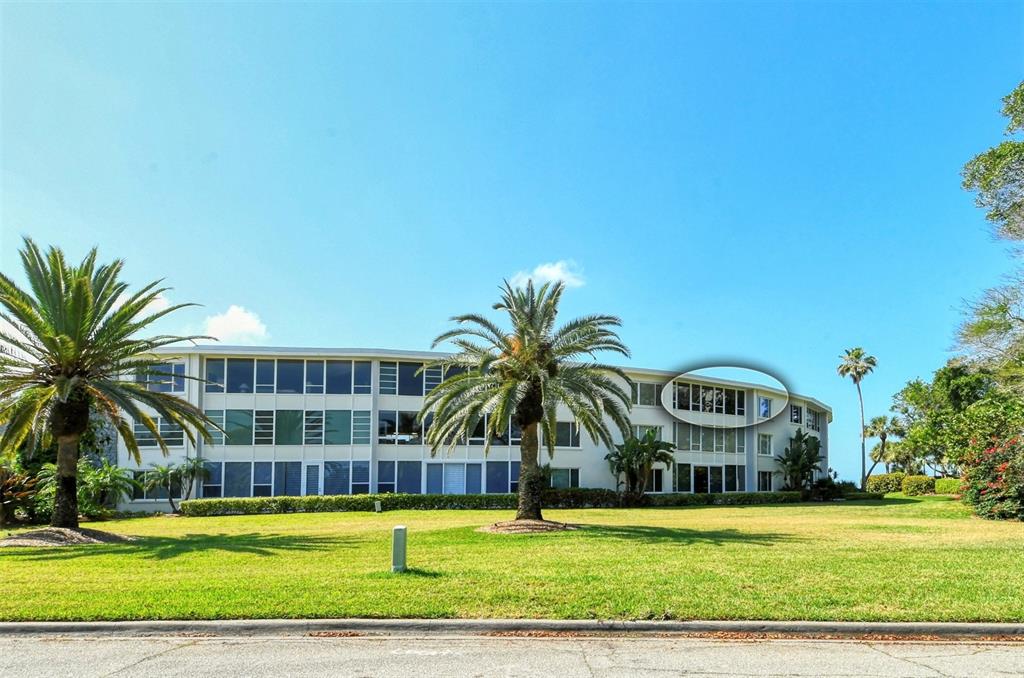 A three-story apartment building with a circled top-floor unit and surrounding palm trees — 100 SANDS POINT ROAD UNIT 324, LONGBOAT KEY, FL