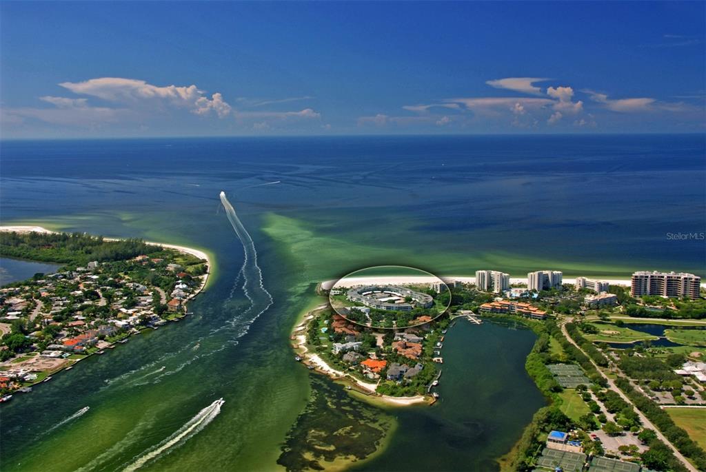 An aerial view of a coastal residential area with a circular building highlighted — 100 SANDS POINT ROAD UNIT 324, LONGBOAT KEY, FL
