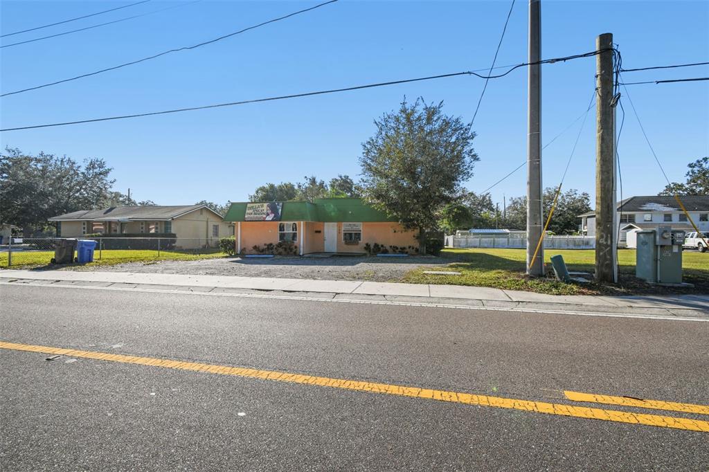 A single-story commercial building with a green roof sits behind a gravel parking lot — 109 E ROBERTSON STREET, BRANDON, FL