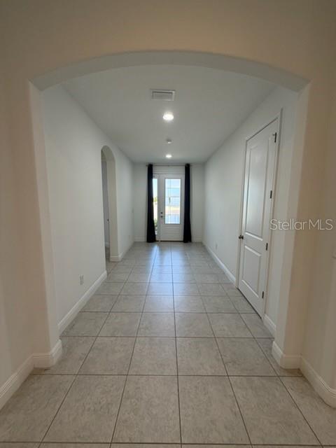 A tiled hallway features an arched entryway, recessed lighting, and a door leading outside — 3918 GAVIOTA DRIVE, RUSKIN, FL