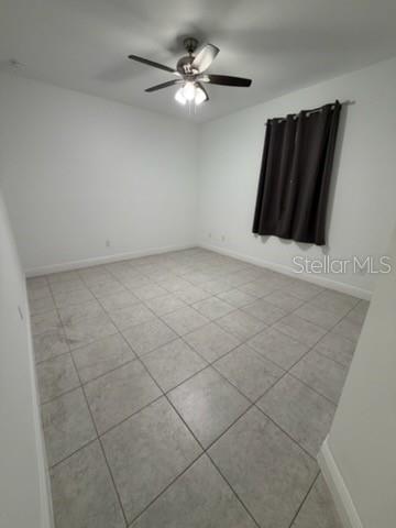 An empty bedroom features light-colored tile flooring, white walls, and a ceiling fan — 3918 GAVIOTA DRIVE, RUSKIN, FL
