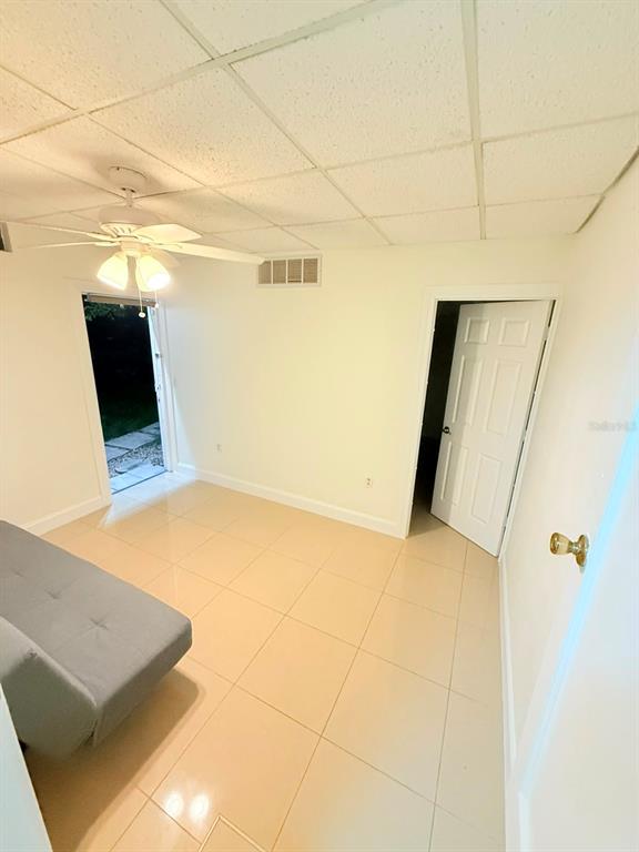 A room with light tile flooring, a ceiling fan, a door to the outside, and a doorway — 2300 SW 24TH STREET, MIAMI, FL