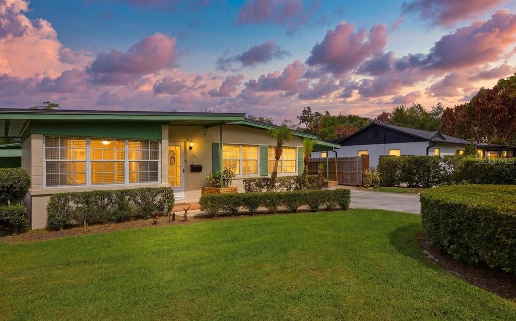 A single-story house with a green roof, light-colored siding, and a manicured lawn at sunset — 516 S HIGHLAND AVENUE, WINTER GARDEN, FL