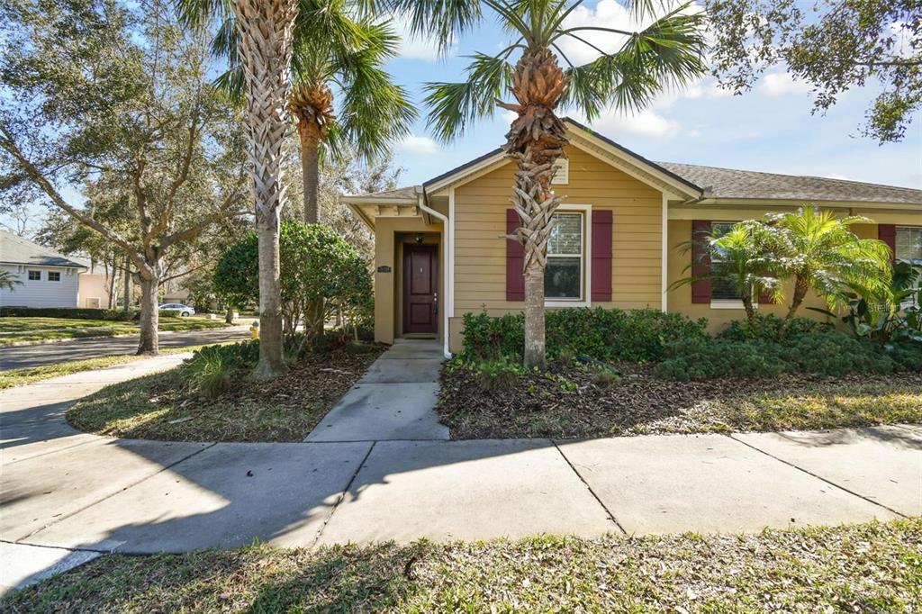 A single-story house with tan siding, red shutters, and palm trees in the front yard — 11329 RAVINIA PARK BOULEVARD, TAMPA, FL