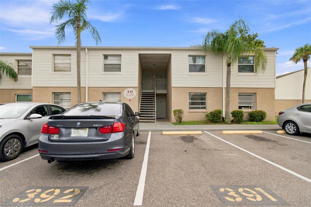 A two-story apartment building exterior with a parking lot in the foreground — 7210 N MANHATTAN AVENUE UNIT 1014, TAMPA, FL