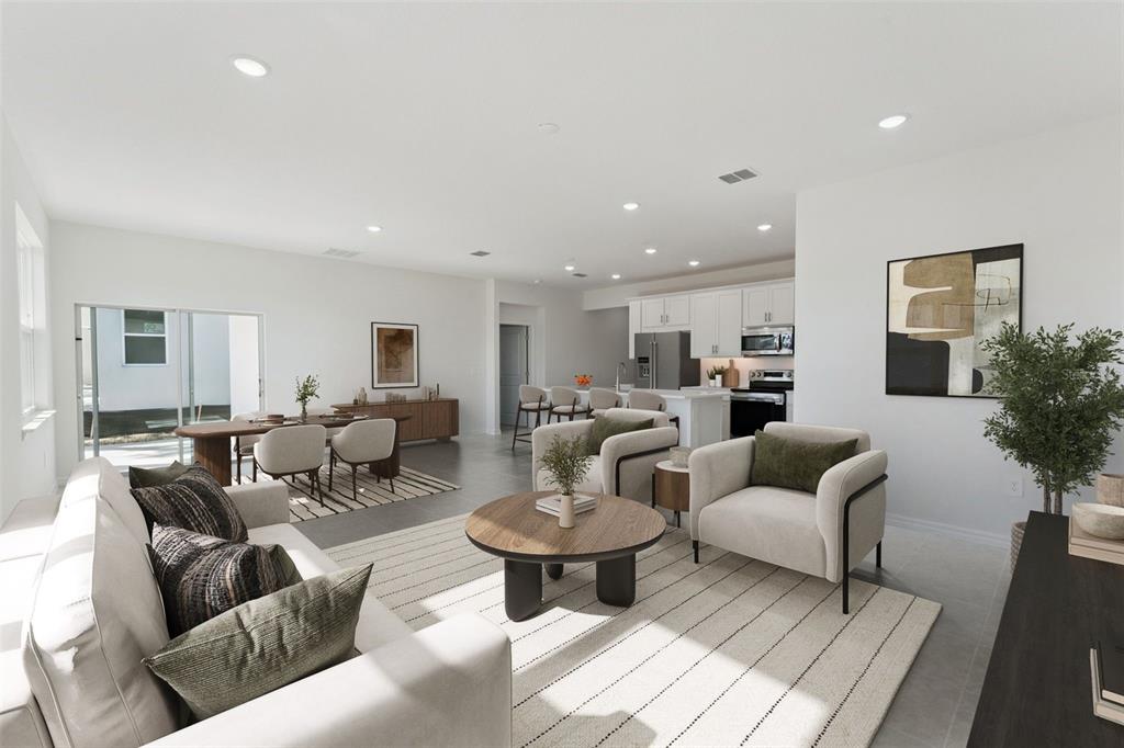 An open-concept living and dining area features neutral furniture, a round coffee table, and kitchen — 4275 DARBY COURT, EUSTIS, FL