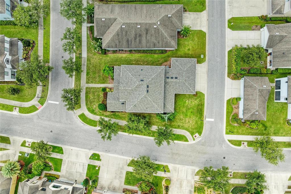 An aerial view shows a residential neighborhood with several houses, paved streets, and green lawns — 20126 OUTPOST POINT DRIVE, TAMPA, FL