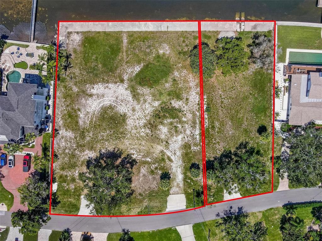 An aerial view shows two adjacent vacant waterfront lots outlined in red along a road — 621 N MAYO STREET, CRYSTAL BEACH, FL